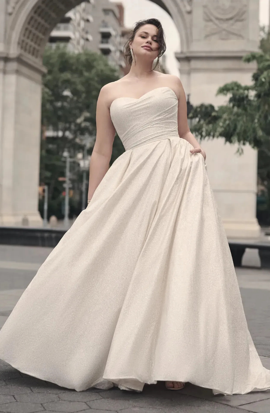 model is wearing a sleeveless plus size ball gown