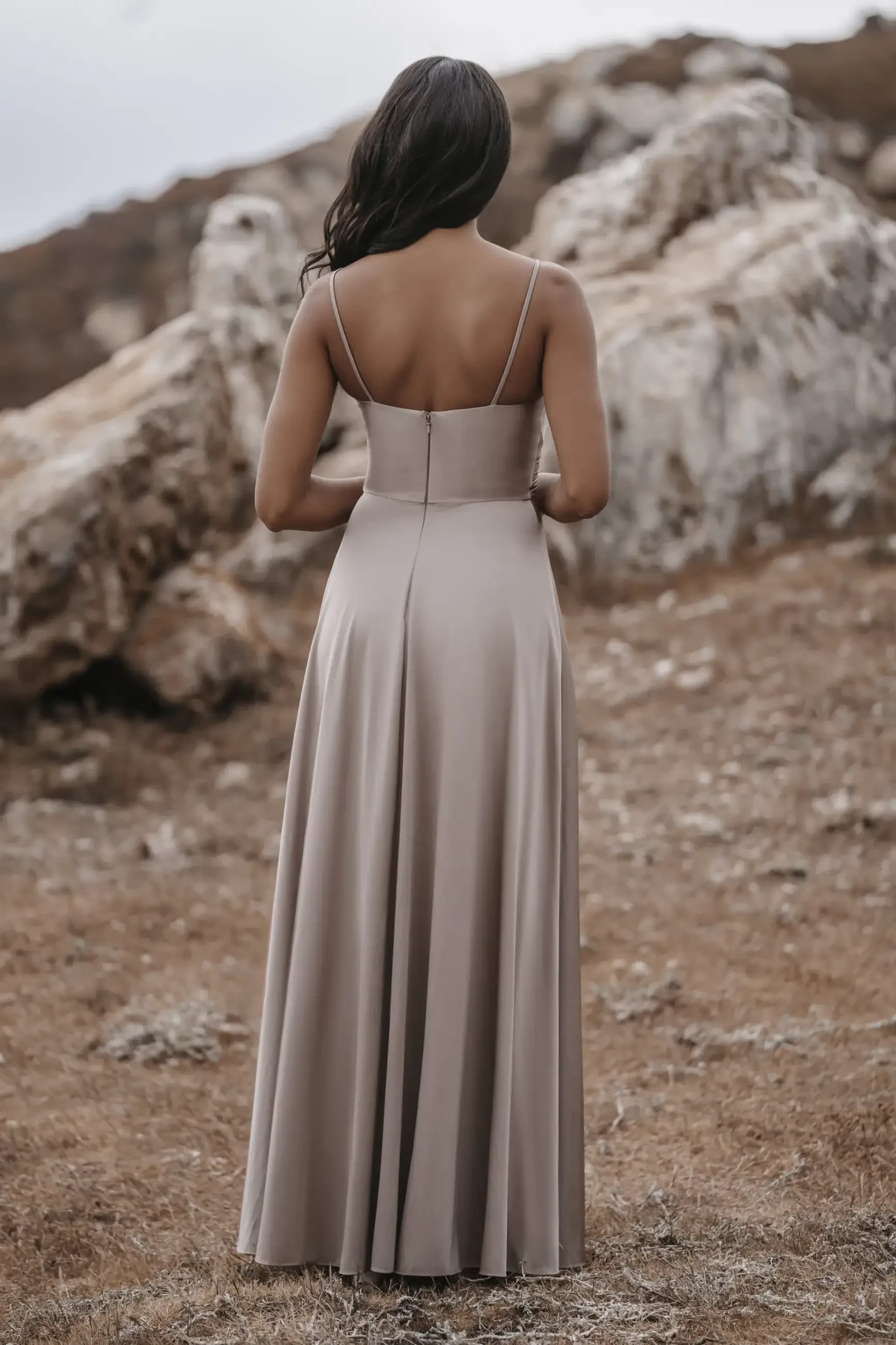 model is wearing a sleeveless a-line taupe bridesmaid dress