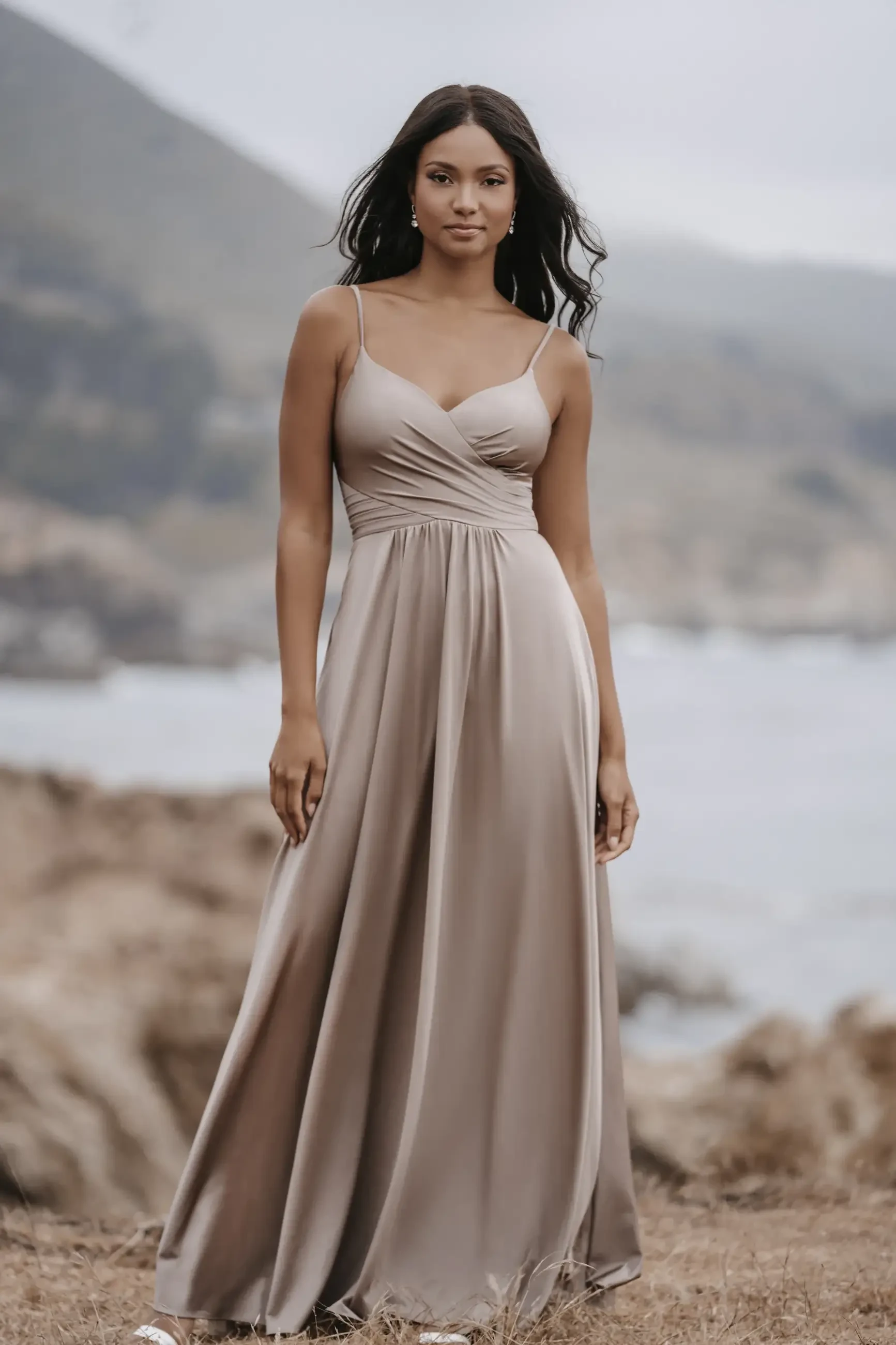 model is wearing a sleeveless a-line taupe bridesmaid dress