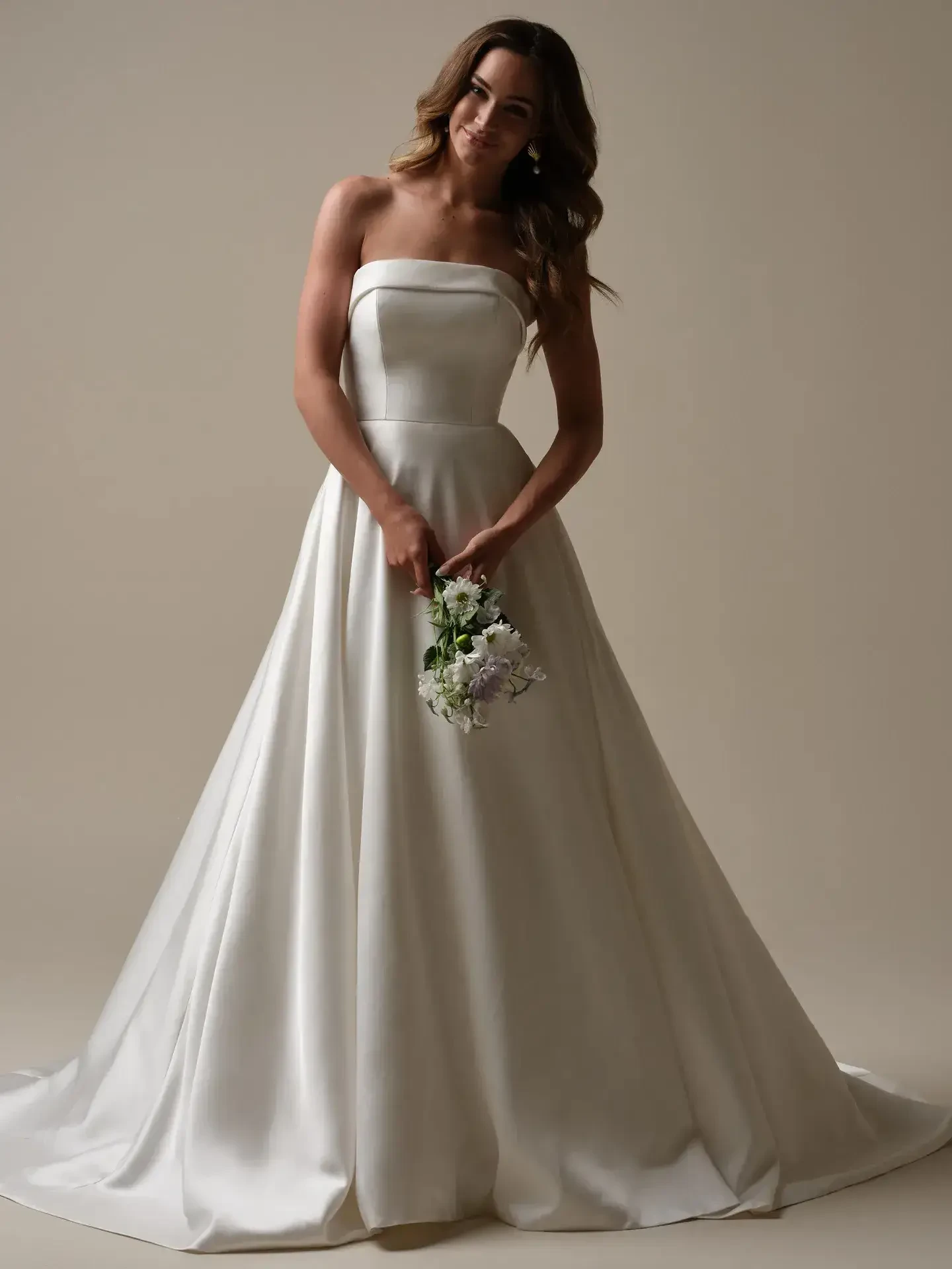 model is wearing a strapless ball gown wedding dress by maggie sottero