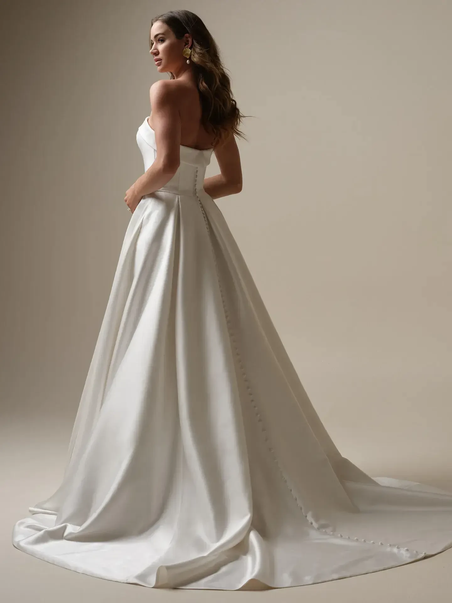 model is wearing a strapless ball gown wedding dress by maggie sottero