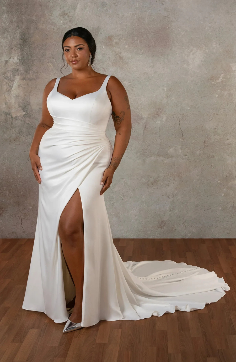 model is wearing a sleeveless plus size bridal gown