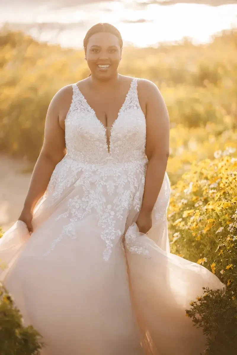 model is wearing a plus size sleeveless wedding dress