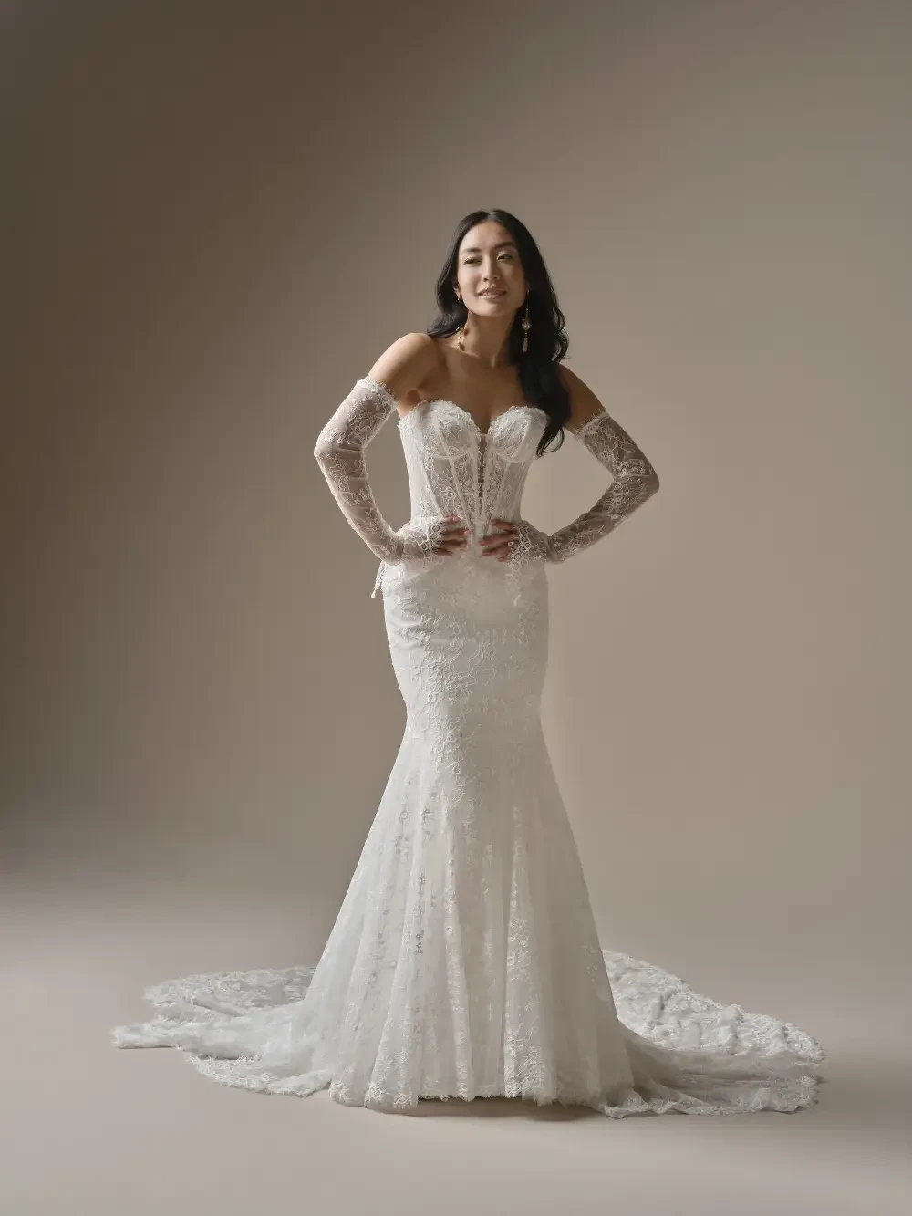 model is wearing a fit and flare wedding dress with long lace sleeves