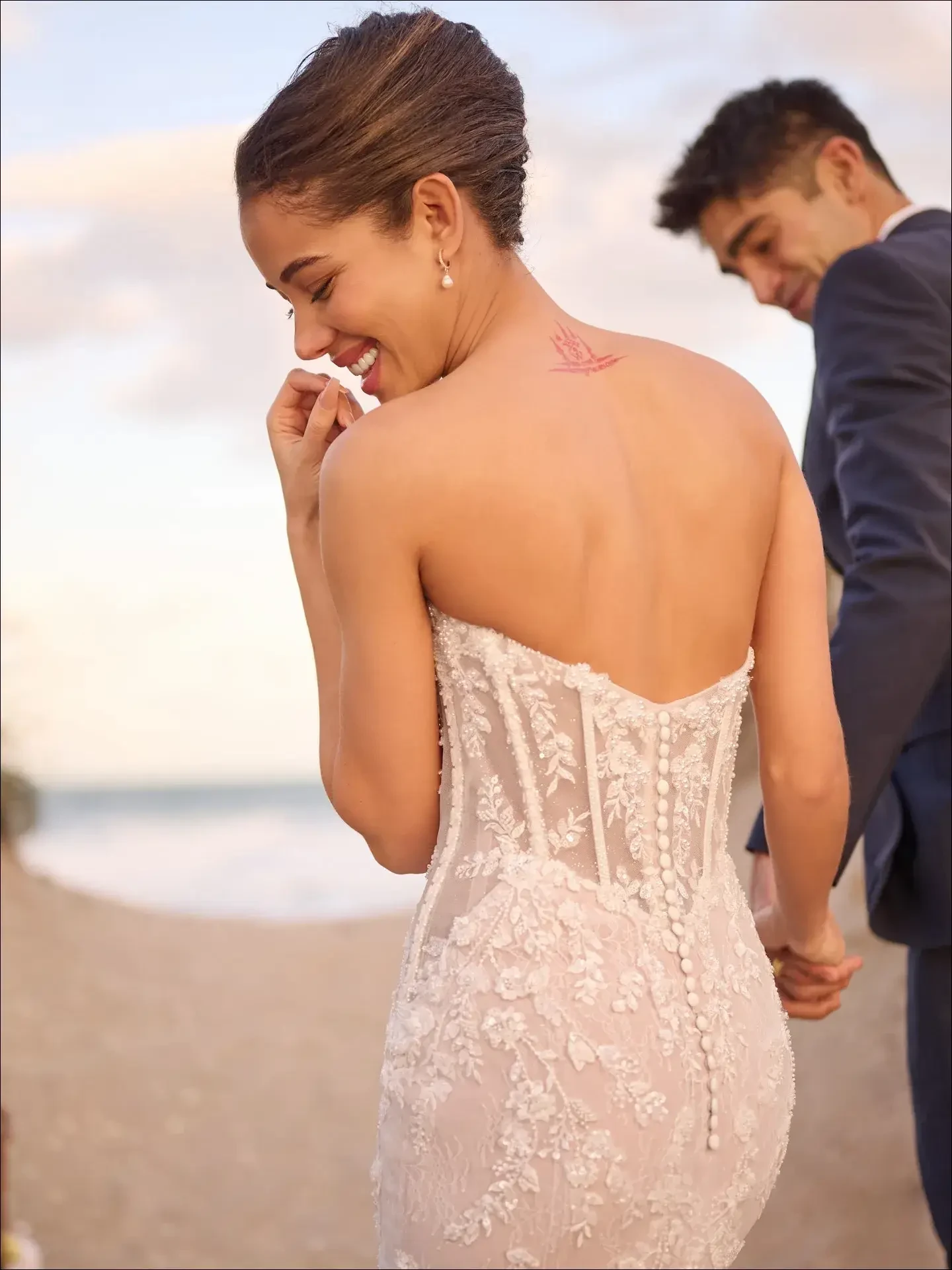 model is wearing a strapless lace fit and flare wedding dress by maggie sottero