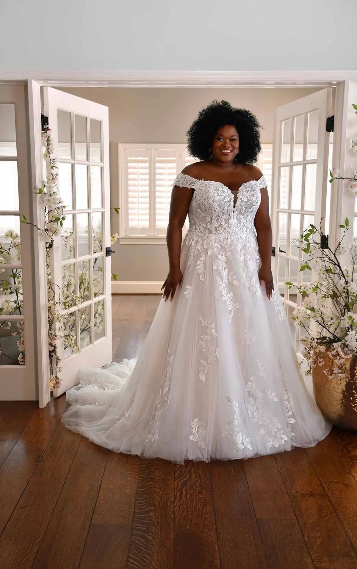 model is wearing an off the shoulder a-line wedding dress