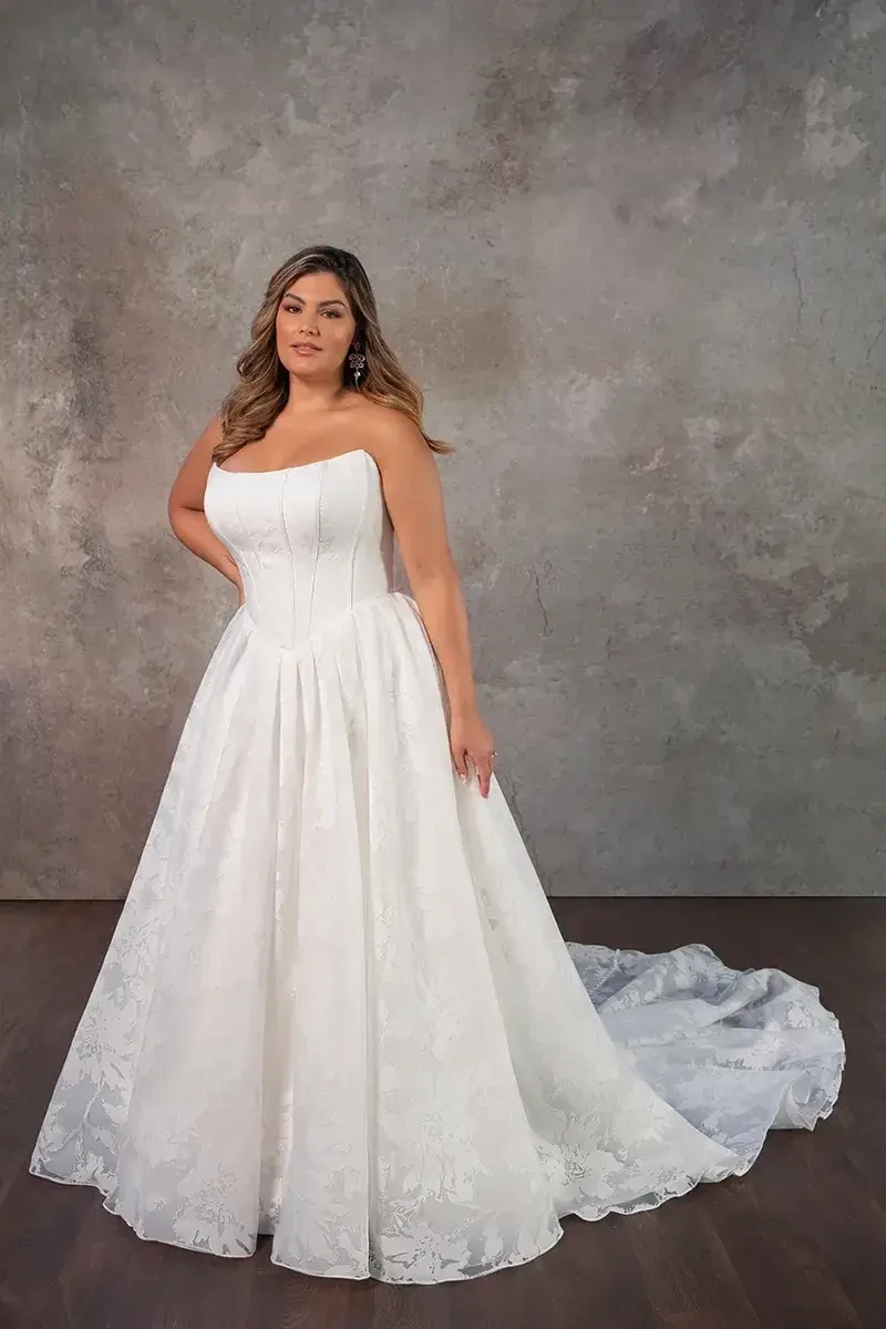 Model is wearing a strapless ball gown in organdy jacquard featuring a scoop neckline and full skirt.