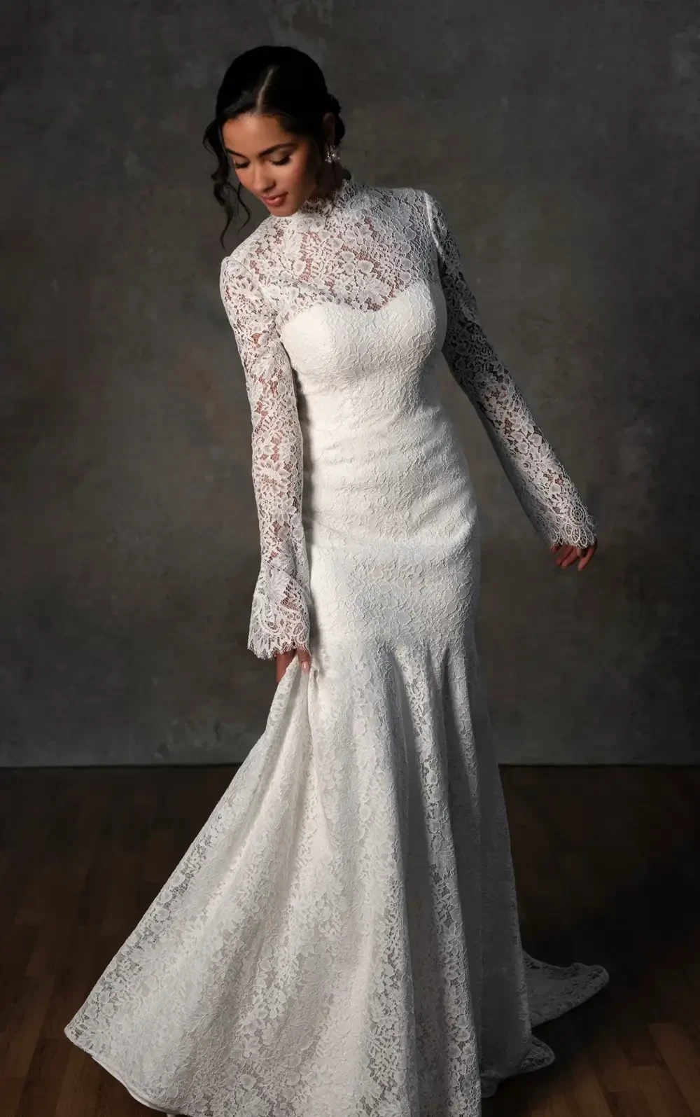model is wearing a high neckline long sleeve lace bridal gown