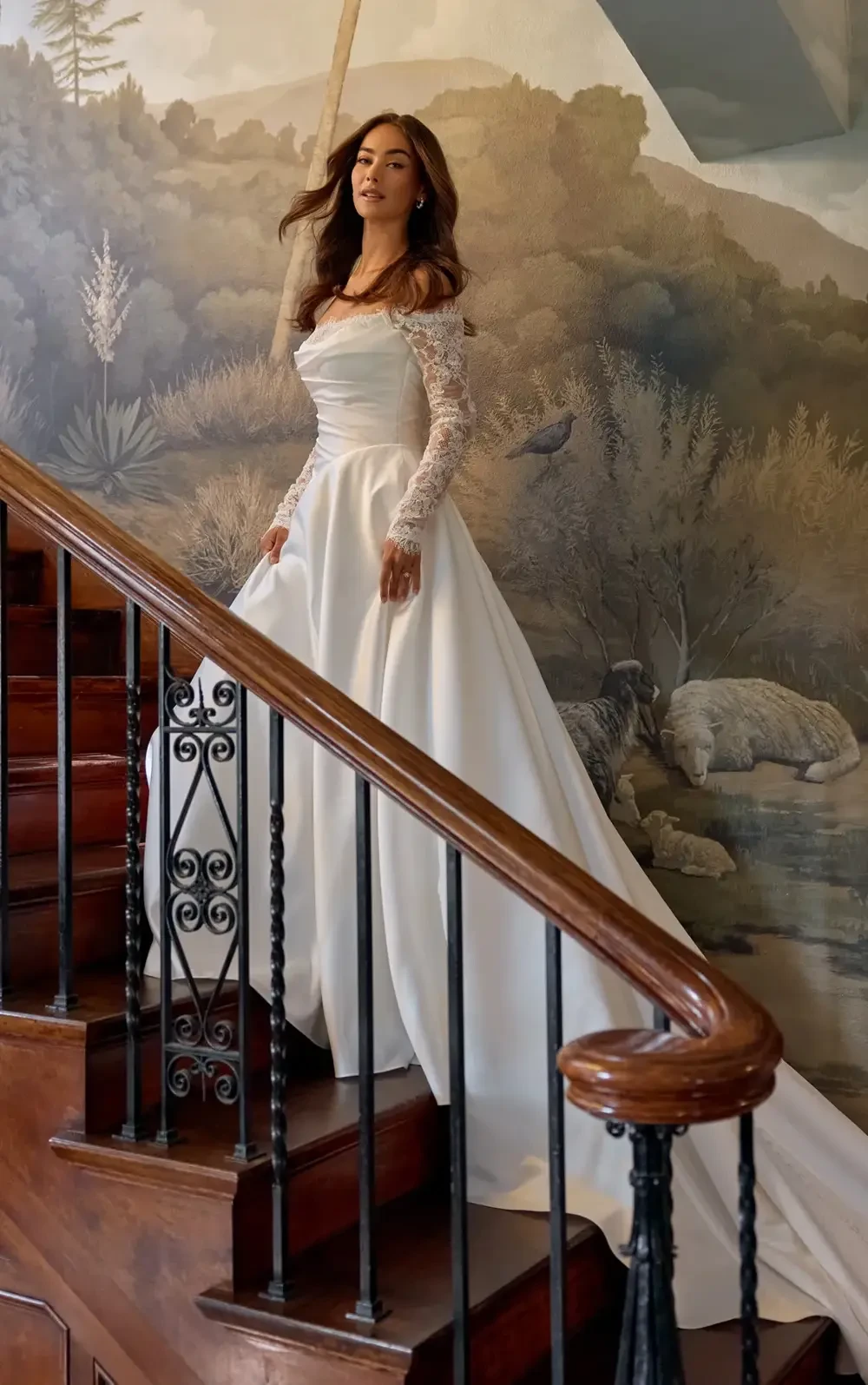 model is wearing a lace long sleeve ball gown