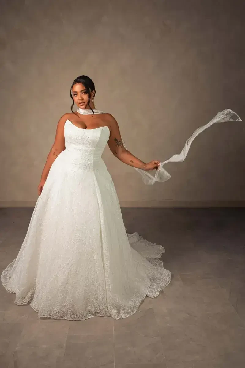 model is wearing a strapless plus size bridal gown