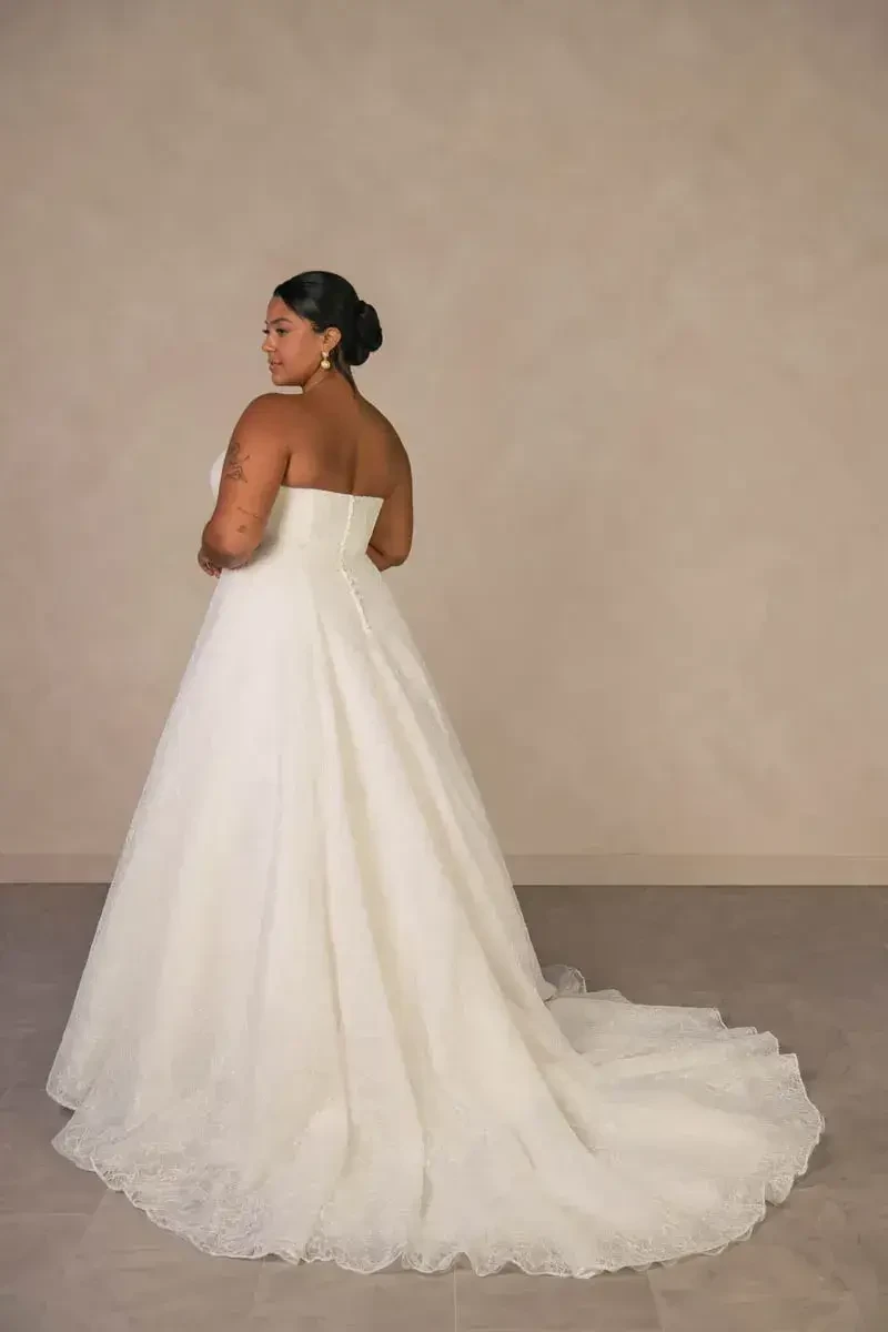 model is wearing a strapless plus size bridal gown