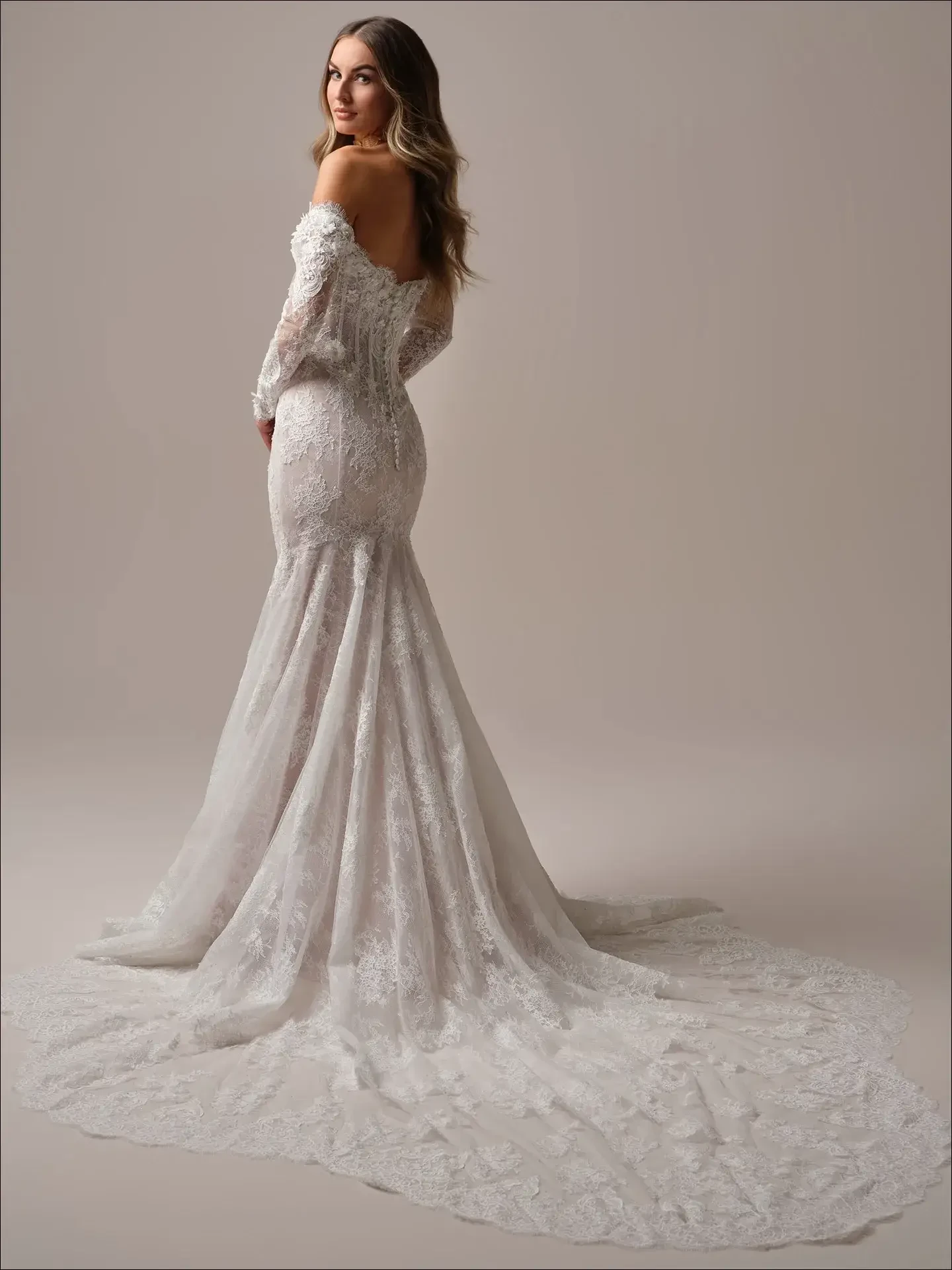 model is wearing a long sleeve lace mermaid wedding dress by maggie sottero